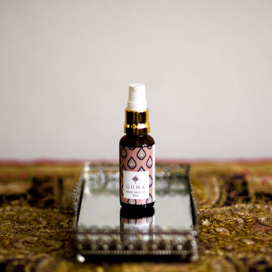 Bottle of Guna's Soma Face Oil sitting on a mirror tray