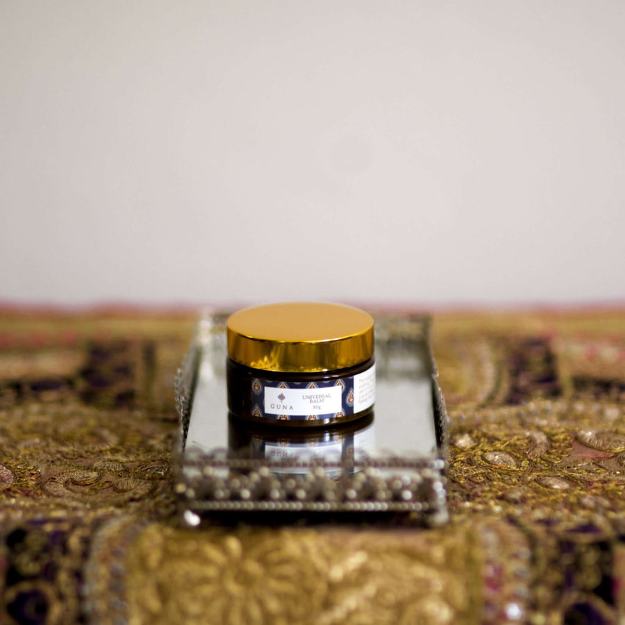 A jar of Guna's Universal Balm on a mirror tray