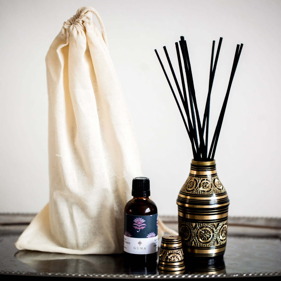 Guna's brass diffuser bottle with a 50ml bottle of Guna's diffuser oil, and a cloth bag on a silver tray