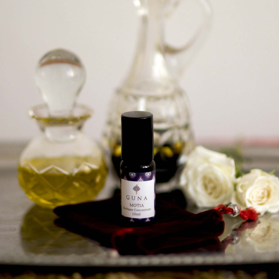 A bottle of Guna's Motia Perfume Concentrate sitting on a silver tray