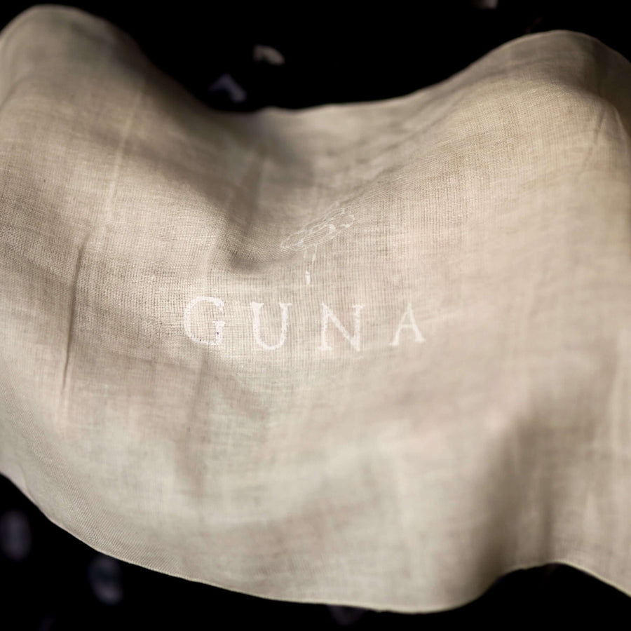 Guna's Muslin Washcloth held open with the Guna logo visible in the centre in white